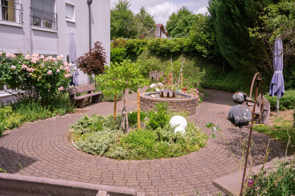 Der Innenhof mit rundem Beet und Bänken zum Verweilen